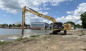 Kettenbagger Caterpillar der Eggers Kampfmittelbergung bei wasserseitiger Kampfmittelsondierung am Ufer des Torinstandsetzungsdocks in Brunsbüttel.