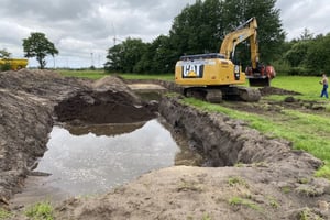 Bagger bei der Ausräumung einer Wassergrube zur Kampfmittelbergung in Leck, Schleswig-Holstein.