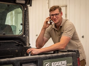 Eggers Mitarbeiter beim Telefonieren an ein Eggers Auto gelehnt