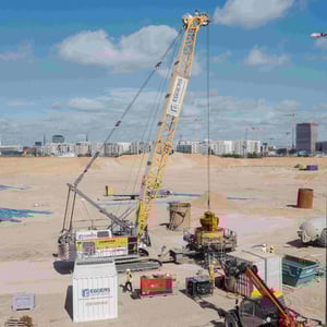 Luftaufnahme eines Liebherr Seilbaggers der Firma Eggers mit gelbem Bohrgerät bei der Tiefbohrung zur Kampfmittelsondierung auf dem Grasbrook in Hamburg.