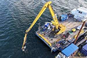 EGGERS Marine Service: Langarmbagger mit Unterwasser-Multitool (Korb & Sensorplatte) sondiert vom Jack-Up-Ponton. Einsatz zur Erkundung, Kampfmittelbergung und Entsorgung von Munitionsaltlasten in Nord- und Ostsee, Pelzerhaken Nord.