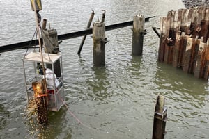 Rethebrücke Hamburg: Arbeiter schneidet im Hängekorb einen Stahlträger über dem Wasser. Rückbau im Hafen, Vorbereitung der Kampfmittelsondierung.